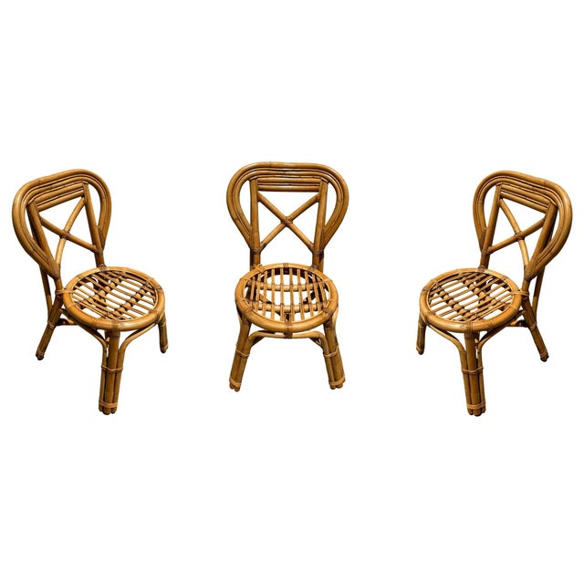 A restored set of 3 mid-century rattan dining chairs features an elegant stick rattan seat and Heart back design. The...