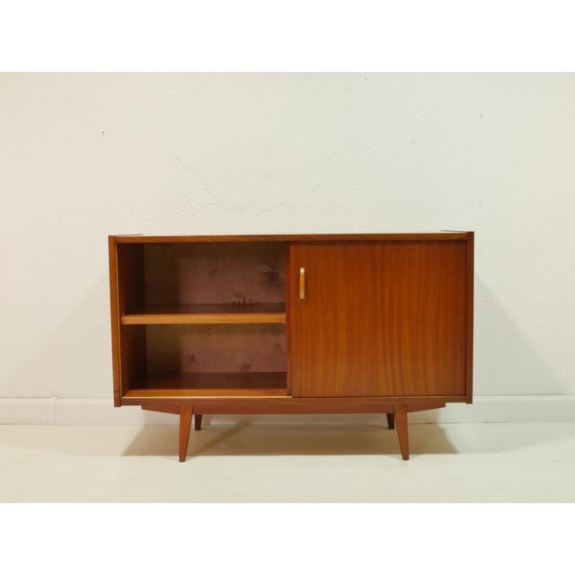 This original sideboard from the 1960s combines functional design with the warm elegance of the mid-century modern style....