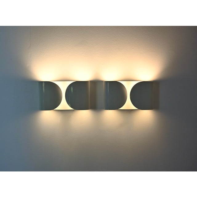 Pair of white metal wall sconces by Afra & Tobia Scarpa. Model: Foglio. Stamped Flos. Wear consistent with age and time....