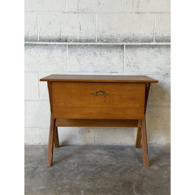 This sewing table features a striking X-frame base and an angled profile. The tilt-out bin reveals multiple compartments...