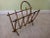 Neat brass colored metal magazine rack with a faux bamboo design. Textured finish and sturdy frame.