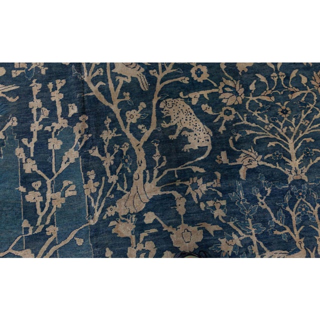An early 20th century Indian antique rug, the blue field with an overall whimsical design in beige of blossoming trees and...