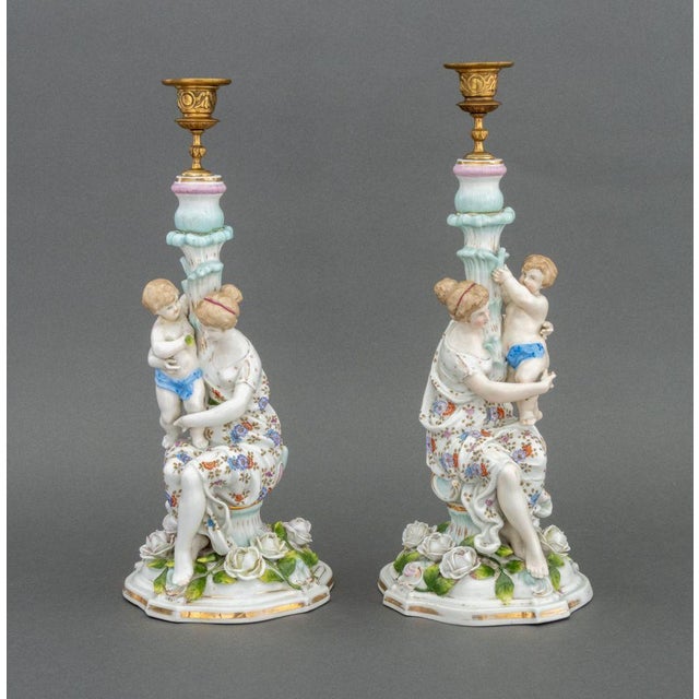 Pair of Meissen Style Porcelain Figural Candlesticks, each in the form of a seated woman holding a child in rose garden,...