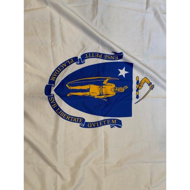 This is a late 20th century vintage Massachusetts State Flag. It features the blue coat of arms with a white star and...