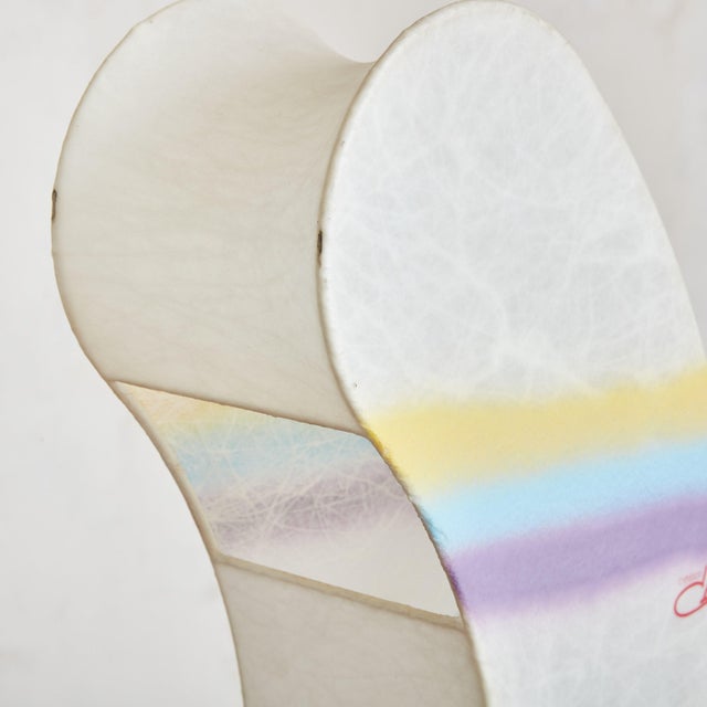 A 1970s Italian rainbow cocoon table lamp designed by Cazal Crèation. This playful lamp is composed of off-white parchment...