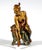 A girl with her hair tied up, sitting on a stool in her underwear, leaning forward slightly as she slips her foot into her...
