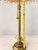Elegant vintage table lamp featuring a richly detailed brass-tone metal base with an ornate decorative foot and turned...