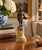 A Grand Tour–style classical figure in brass, mounted on a cylindrical marble base. The slightly more relaxed posture and...