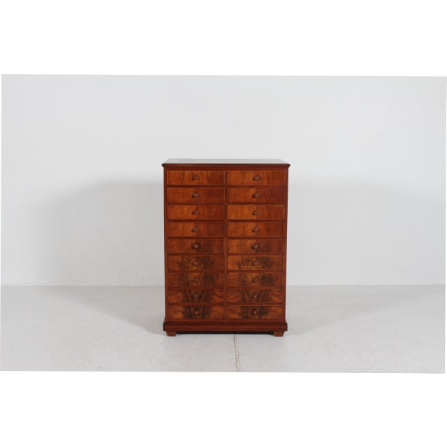 The chest of drawers with numerous drawers for storage is mainly made of walnut with pine inside. It was made around 1920...