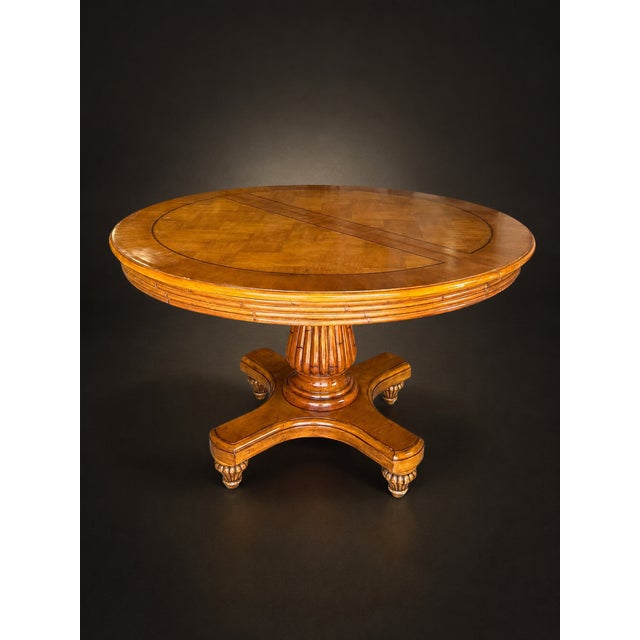 A striking vintage round dining table featuring a richly figured burl wood finish, decorative geometric inlay, and an...