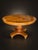 A striking vintage round dining table featuring a richly figured burl wood finish, decorative geometric inlay, and an...