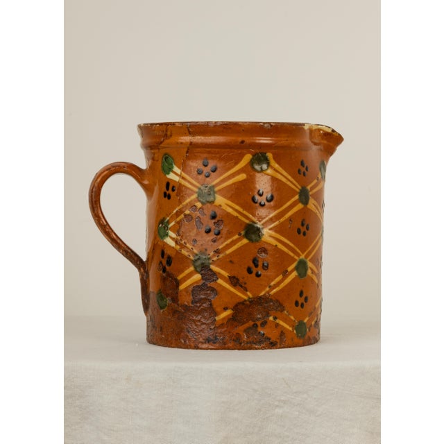 French Savoie Glazed Earthenware Pitcher decorated with hand-trailed yellow slip lattice, green dot rosettes and manganese...