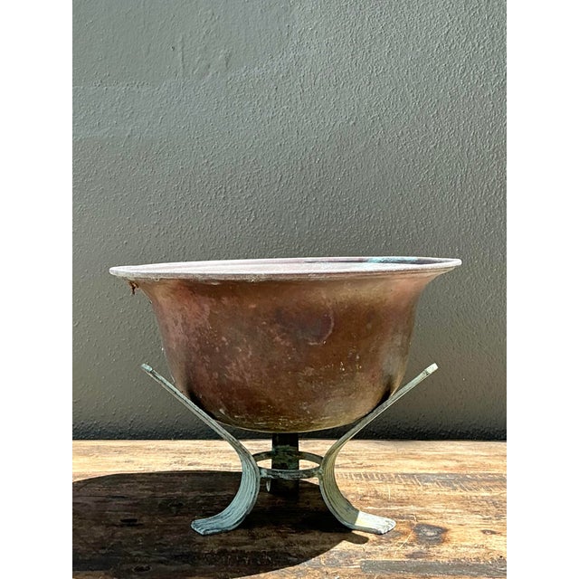 This vintage copper bowl on a verdigris stand is a masterclass in organic texture and aged elegance. The bowl features a...