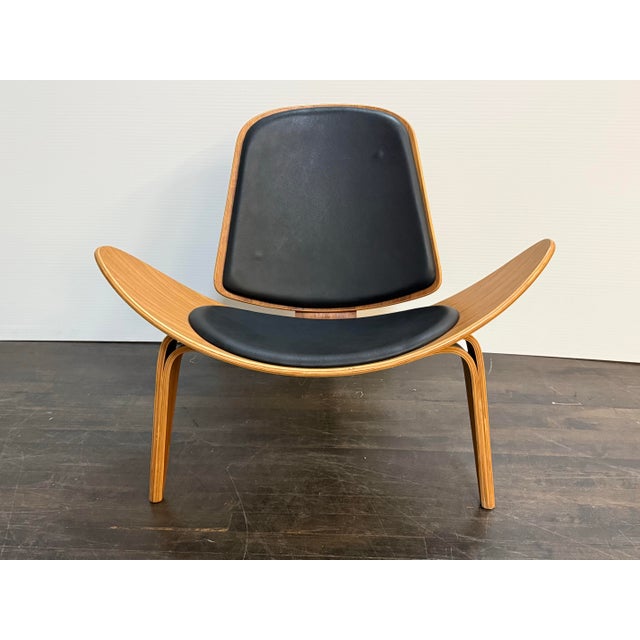 Design Plus Gallery presents a Shell Chair in the style of Hans J. Wegner. This lounge chair draws from the iconic three-...