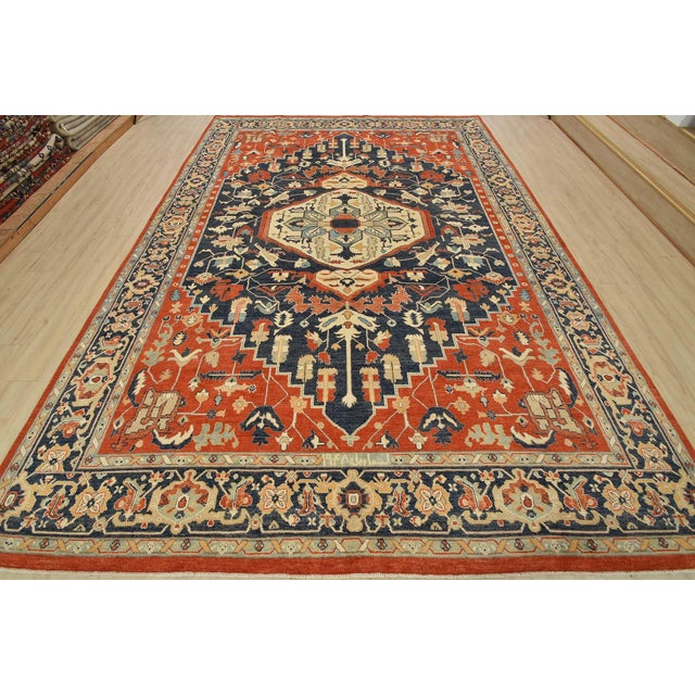 A traditional Heriz rug hand-knotted with fine wool on a cotton foundation. This oriental rug features a central geometric...