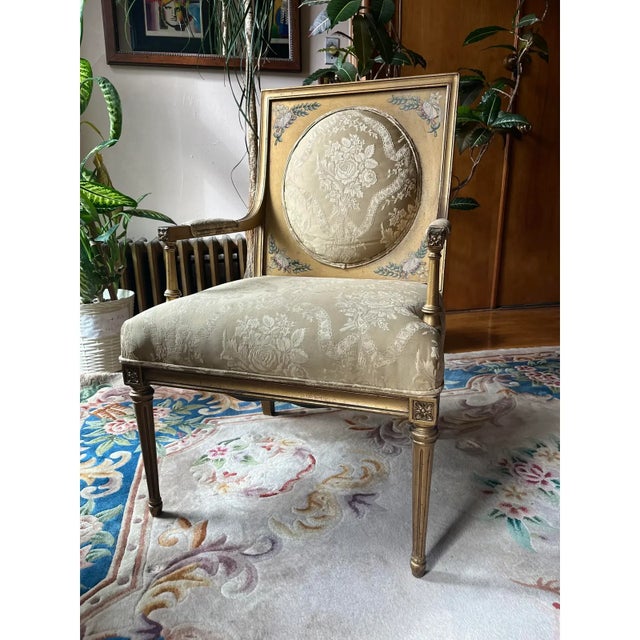 Early 20th century French Louis XVI–style armchair with a carved wood frame and fluted legs. The frame features hand-...