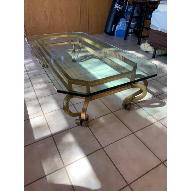 Fine Hollywood Regency gilt metal and glass coffee table. Glass top with beveled edge and canted corners. Glass top is...