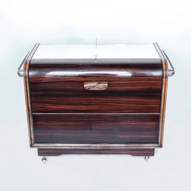 An Art Deco serving/drinks trolley with mirrored top. Double ice-box to one side with drinks cabinet to opposite side,...