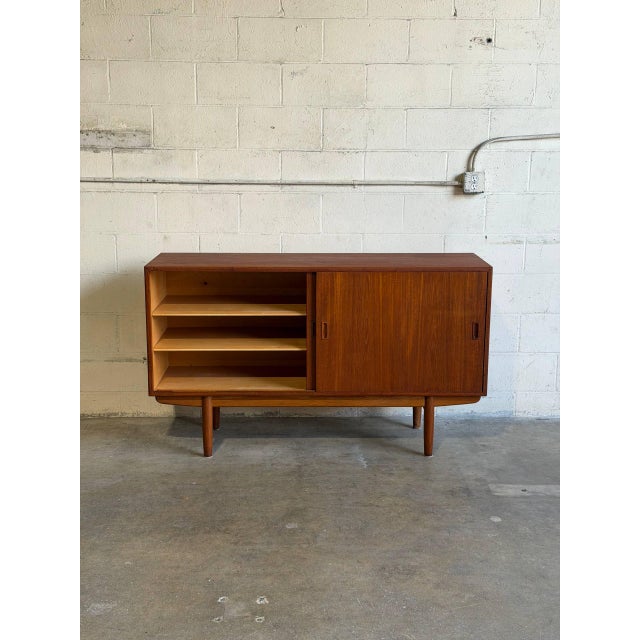 This exceptional sideboard features a clean rectangular profile with smooth sliding doors. The dual-sectioned interior...