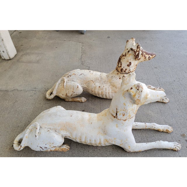 A pair of life-size recumbent cast iron Greyhound or Whippet dogs by renowned maker J. W. Fiske foundry of New York....