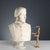 Bust of a noble lady in white marble depicted with a serious look, hairdo and clothing typical of that era. This piece is...