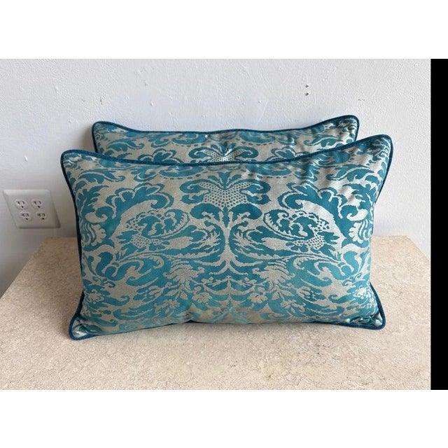 This elegant pair of pillows features Fortuny textile fronts in a rich teal and silvery-gold damask pattern, showcasing...