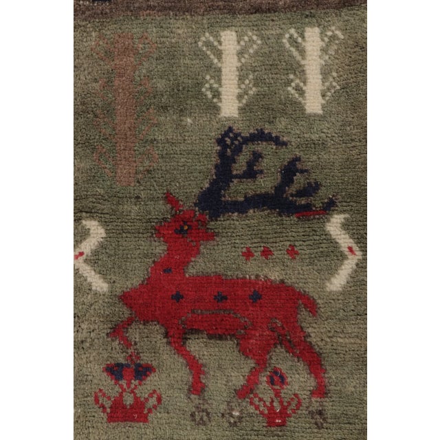 Hand-knotted in wool and originating circa 1950-1959, this 1x8 vintage Gabbeh pictorial extra-long runner is from...