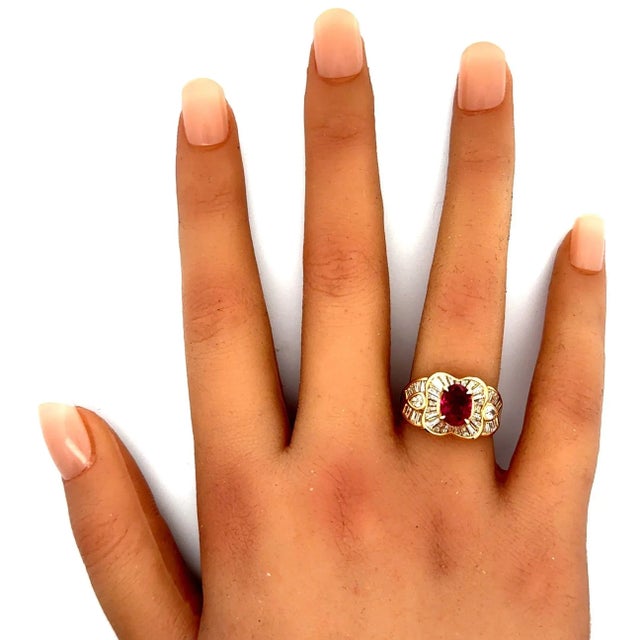 An exquisite oval-shape ruby takes center stage. Weighing 1.81 carats, it radiates a deep and vibrant red hue with...