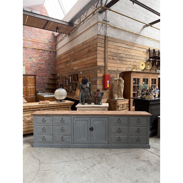 This handcrafted sideboard features a grey-patinated body and a natural wood top. It comprises eight practical drawers...