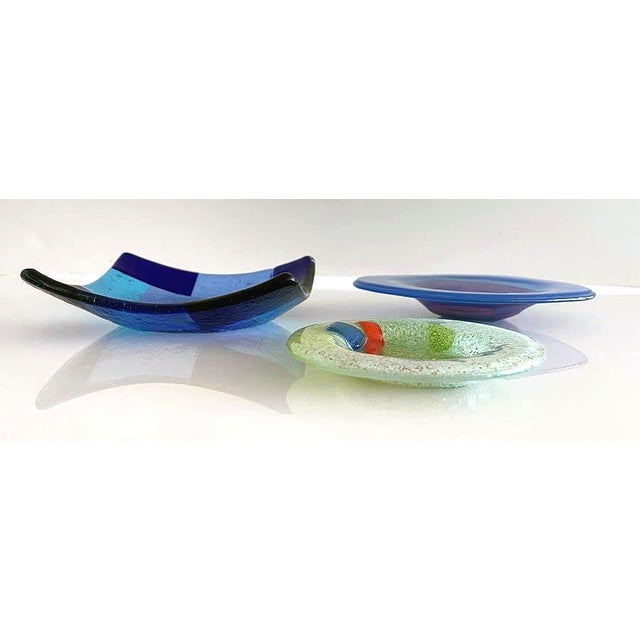 These are three beautiful Studio Glass pieces. Square measures 5.5" M logo Blue measures 6" signed Higgins Green dish is...