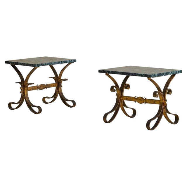 A French Art Deco side table from the 1950s, where structure and ornament meet in balance. The base is hand-wrought in...