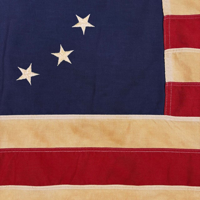 This vintage Betsy Ross American flag is made from a cotton cloth, with fully sewn stripes and 13 embroidered stars....