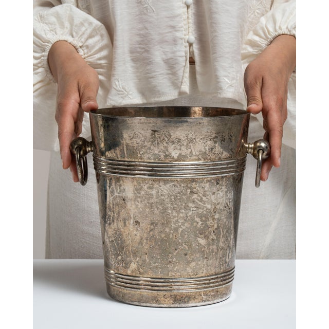 This 20th century silver-plated champagne bucket from France is plated in silver with a banded body and a pair of ring...