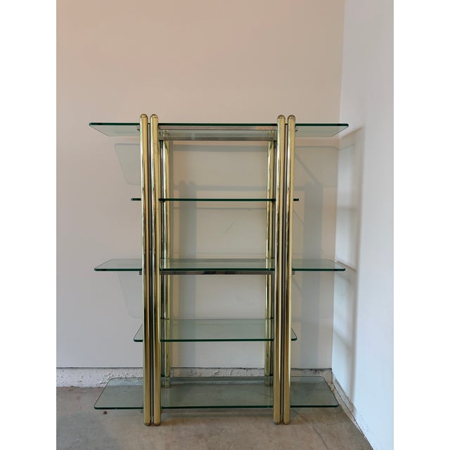 Beautiful vintage brass and glass shelving unit with a sculptural, architectural frame and substantial glass shelves with...