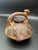 Peruvian bridge-spout vessel, a form of drinking or ritual container featuring a Jaguar. Made traditionally coil built,...