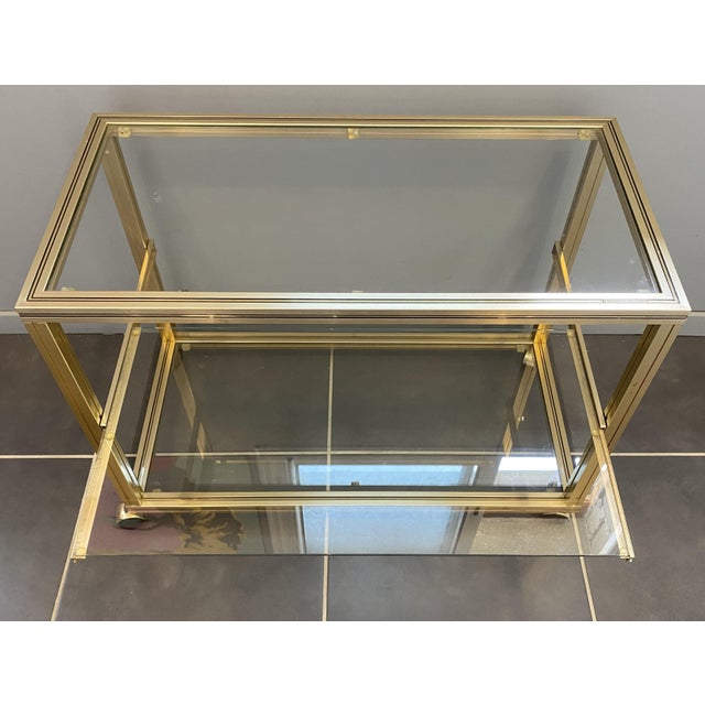 Beautiful rolling cabinet with a square, gold-tone tubular metal frame and three glass shelves. The middle shelf slides...
