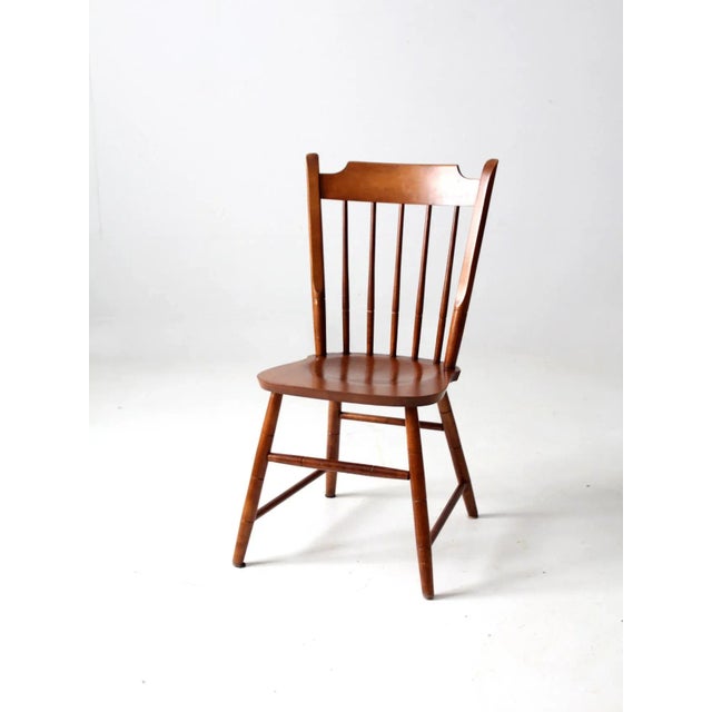 A mid-20th-century Tell City dining chair featuring a sleek, modern Windsor-style silhouette with a classic spindle back...