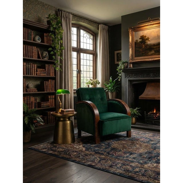 A sophisticated Hungarian Art Deco lounge armchair featuring rich green velvet upholstery, a gently tufted backrest, and...