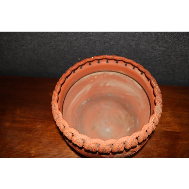 Japanese terracotta jardinère in a warm reddish-orange finish, featuring applied relief decoration of dragons, birds, and...