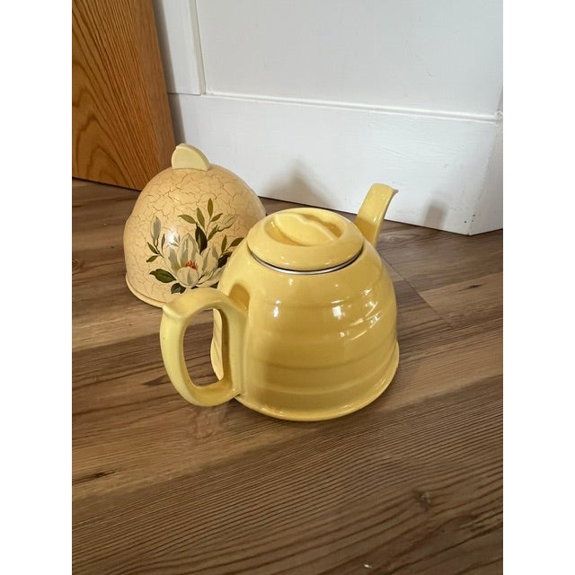 Vintage ceramic teapot with a crackle-glaze yellow finish and a hand-painted white magnolia flower design. Includes...