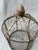 Small vintage chicken wire indoor birdcage or garden cloche with a pointed bud shaped finial. The base opens as a door...