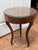 A petite Italian style side table with a richly figured burl wood top over a walnut-veneered drum apron. A single bow-...