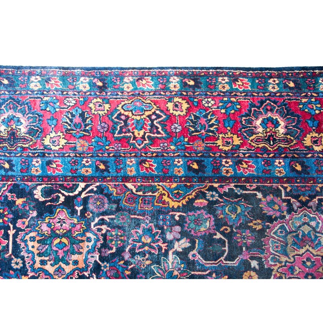 A remarkable early 20th century Persian Kirman rug with the most wonderful mirrored floral pattern woven in jewel-toned...