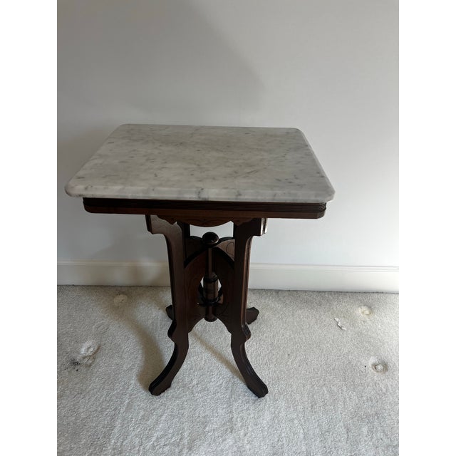 This is a gorgeous antique Victorian Eastlake walnut parlor side table with a square white marble top and carved...