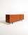 Teak sideboard with three sliding doors and recessed handles, supported by low, turned, black-lacquered legs. Danish...