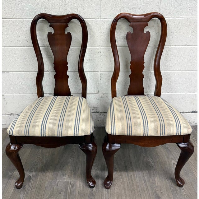 This is a stunning pair of vintage Queen Anne style dining chairs. They feature beautiful cabriole legs, a carved back...