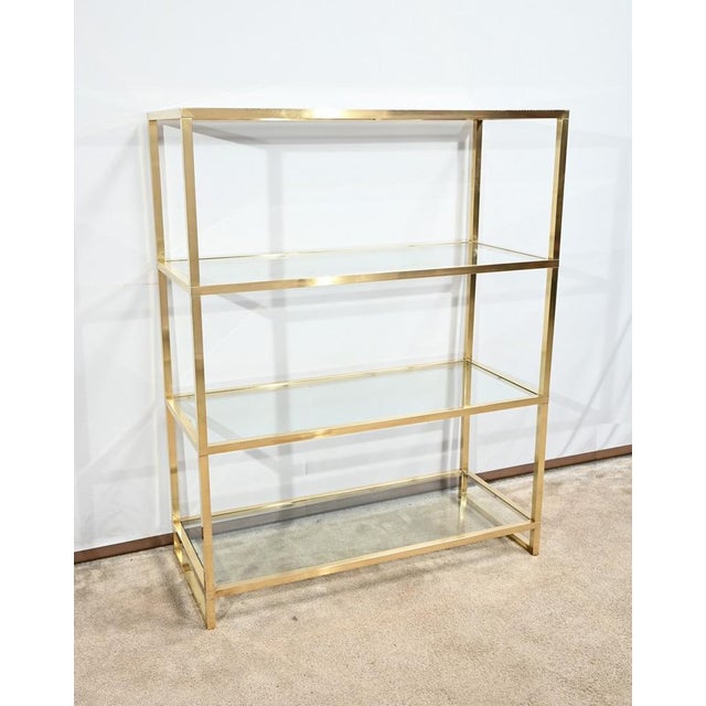 This shelf offers four levels with a glass surface in clear glass. Each of these levels is based on a brass structure of...
