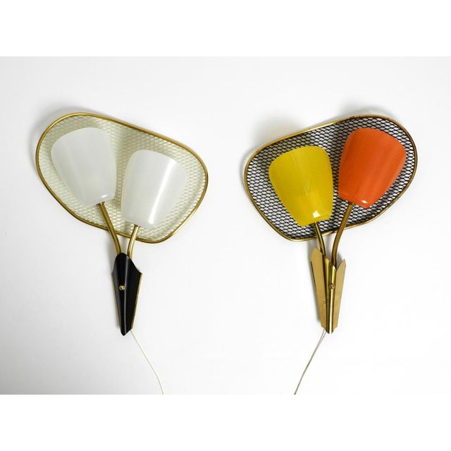 Pair of rare large Mid Century Modern expanded metal wall lamps with acrylic glass shades. Both lamps are still new. They...