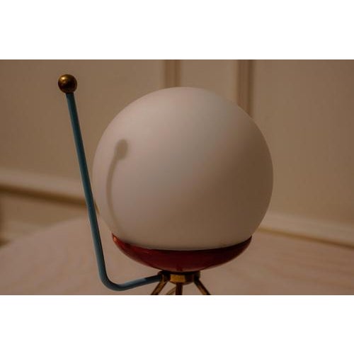 A pair of mid-century modern table lamps showcasing the elegance of Italian design. Each lamp rests on a distinctive brass...