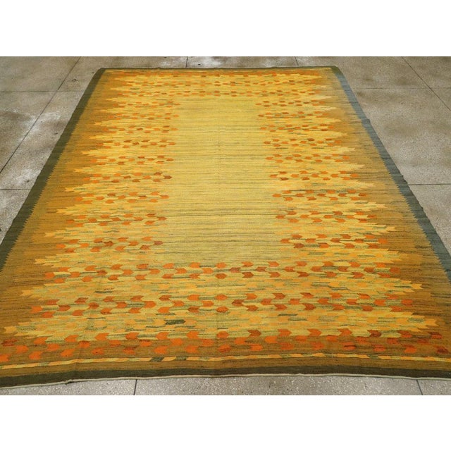 This Mid-20th century Swedish Flatweave Kilim rug, presents a vibrant and beautifully balanced composition that...
